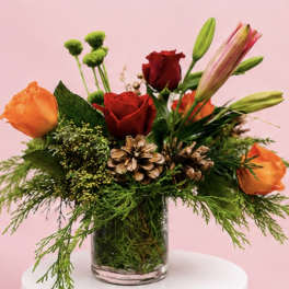 Bouquet of red and orange roses with lilies in a glass vase