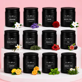 Set of black scented candles on white risers with small floral accents