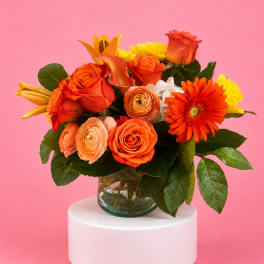 Orange and yellow mixed bouquet in a glass vase