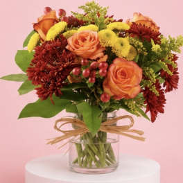 Bouquet of orange roses and red chrysanthemums in a glass vase