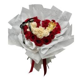 Bouquet of red and cream roses wrapped in white paper with a ribbon