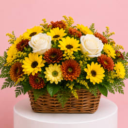 Basket arrangement of yellow daisies, orange mums, and white roses