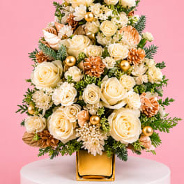 Cream rose arrangement in a gold vase with pinecones and gold ornaments