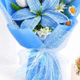 Blue bouquet with crocheted flowers and white daisies wrapped in blue paper
