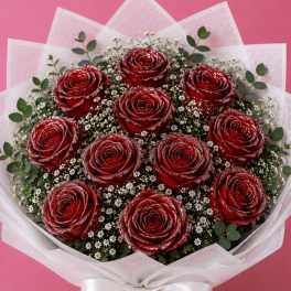 Bouquet of red roses with white filler flowers and a white ribbon wrap