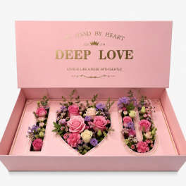 Pink gift box with roses arranged in the letters I, U, and a heart