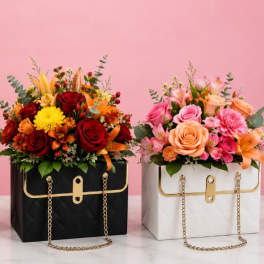 Three floral arrangements in handbag-shaped boxes on a pink background.