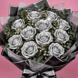 Bouquet of silver roses with baby's breath and eucalyptus, wrapped in black paper with a silver ribbon.