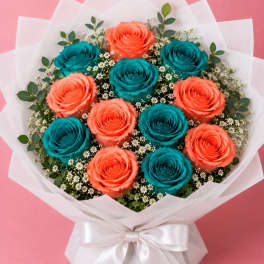 Bouquet of coral and teal roses wrapped in white paper with a satin bow