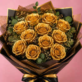 Bouquet of gold roses wrapped in black and gold paper with a ribbon