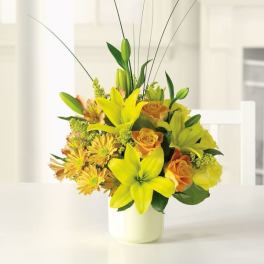 Yellow lilies and orange roses in a white vase