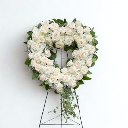 Heart-shaped white rose wreath on a standing easel
