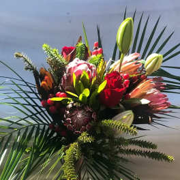 Tropical bouquet with protea, lilies, and red roses