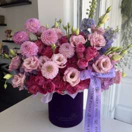 Pink and purple bouquet in a purple hat box with a ribbon