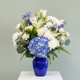 Blue and white floral arrangement in a cobalt vase