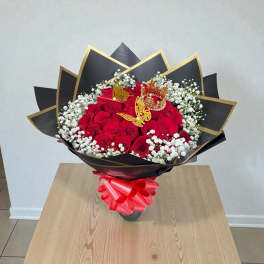 Bouquet of red roses with white baby's breath in black and gold wrap