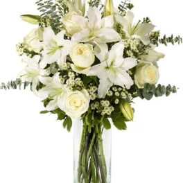 White lilies and roses arranged in a clear glass vase
