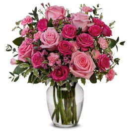 Pink and magenta roses arranged in a clear glass vase