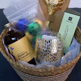 Gift basket with candles, bath soak, and a dried floral bundle