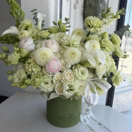 Cream and pale green bouquet in a green hatbox with a white ribbon