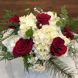 Red roses and white hydrangeas in a clear glass vase