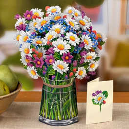 Bouquet of white daisies and purple flowers in a glass vase