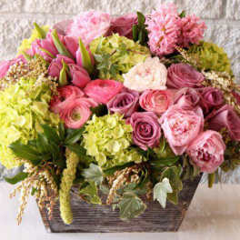Pink and yellow mixed flower arrangement in a rectangular wooden container