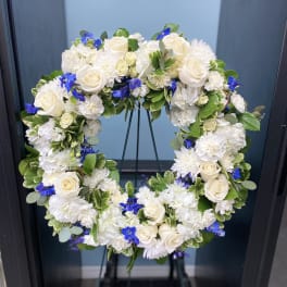 White and blue floral wreath on a stand