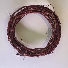 A simple round grapevine wreath on a plain wall