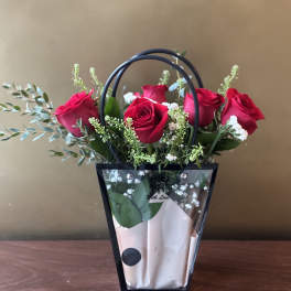 Bouquet of red roses in a black handled gift bag
