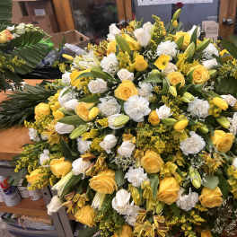 Large yellow and white floral spray with roses, lilies, and carnations