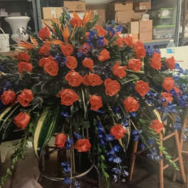 Large floral spray with red roses and blue accents