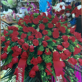 Large standing spray of red roses with red ribbons in a shop