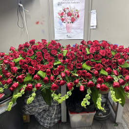 Large arrangement of red roses with green accents on a table
