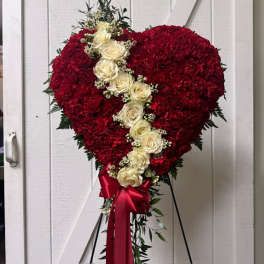 Heart-shaped red floral standing spray with white roses and a red ribbon