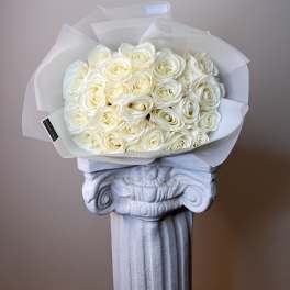 Bouquet of cream white roses wrapped in translucent paper
