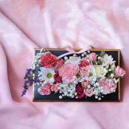 Rectangular floral box with pink and white flowers and a ribbon bow