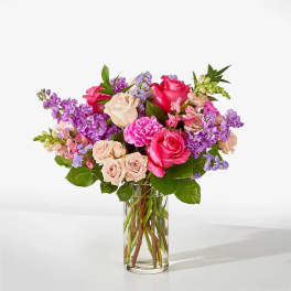 Bouquet of pink and lavender flowers in a clear glass vase