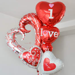 Cluster of heart-shaped red and white balloons with love messages