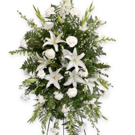 White lilies and carnations in a standing spray on an easel