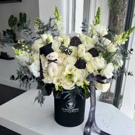 White rose bouquet in a black hatbox with a small teddy bear