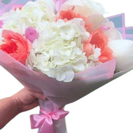 Pink and white bouquet wrapped in translucent paper with a ribbon