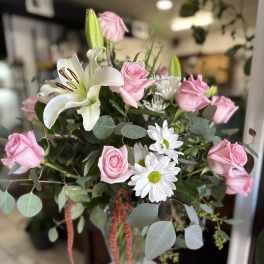 Pink roses and white lilies in a glass vase