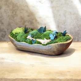 Low moss arrangement in a shallow wooden bowl with small blue accents