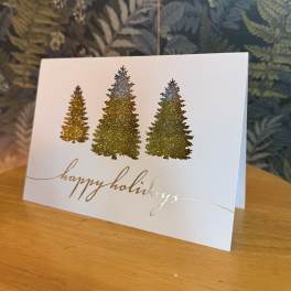 Holiday card with glittery Christmas trees and gold script