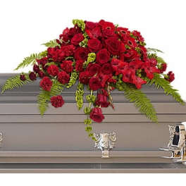 Red rose casket spray with ferns on a gray casket
