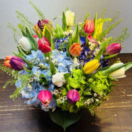 Colorful bouquet of tulips and hydrangeas in a low container