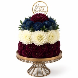 Tiered chrysanthemum arrangement with a gold Happy Birthday topper