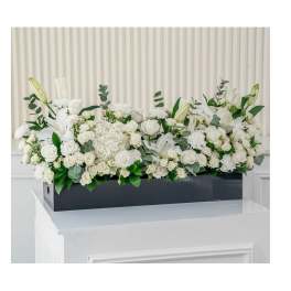 White floral arrangement in a black rectangular box