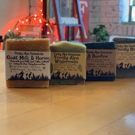 Four labeled bars of soap arranged on a wooden table